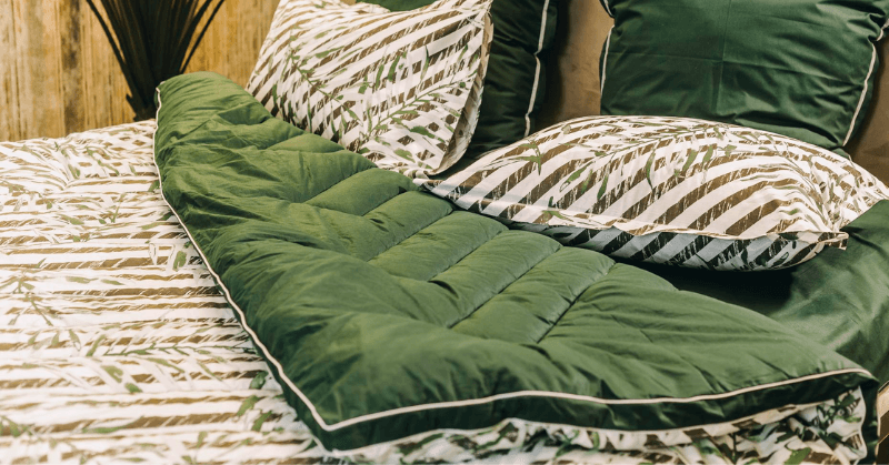 Green printed quilt on a bed Green printed quilt on a bed