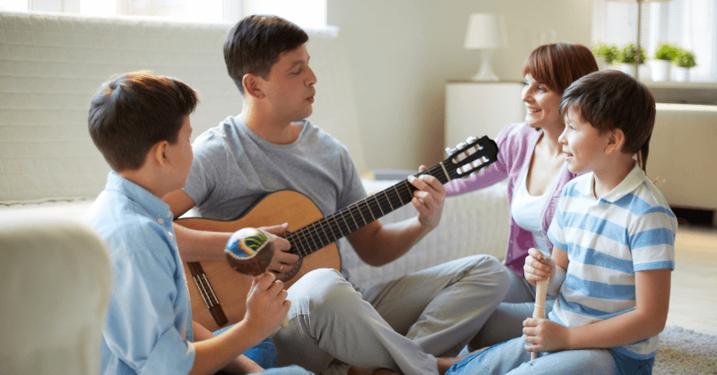 Kids listening to guitar Dad playing the guitar for his family
