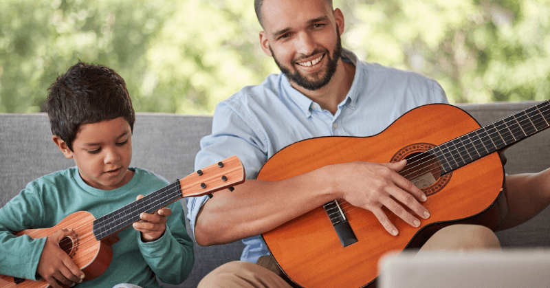 Parent and child guitar Dad and young boy playing their own guitars
